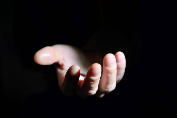 istock Symbolic hand helping on black background 1152396545