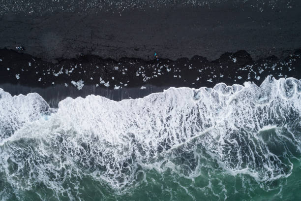istock water foam over black sand at Diamond Beach 1152397103