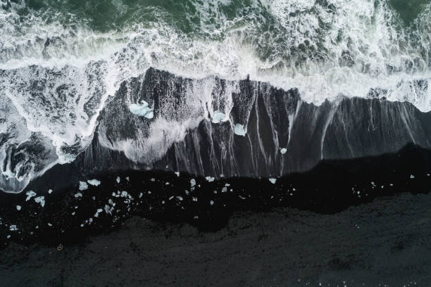 istock water foam over black sand at Diamond Beach 1152397106