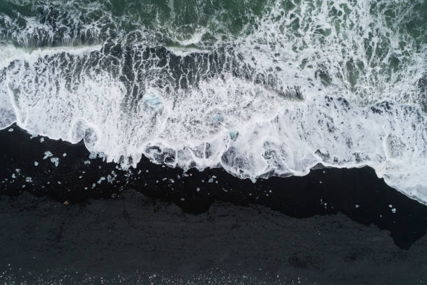 istock water foam over black sand at Diamond Beach 1152397189