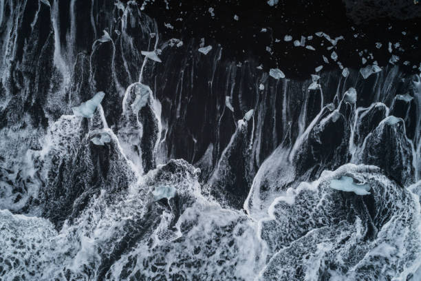 istock water foam over black sand at Diamond Beach 1152397312