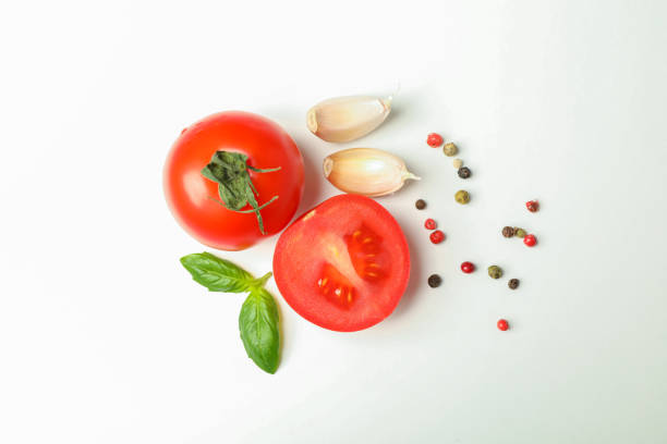 istock Fresh cherry tomatoes with basil, spices and garlic on white background, space for text and top view. Ripe vegetables 1152399397