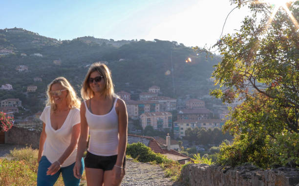 istock Female hikers walk along cobblestones above medieval town 1152401054