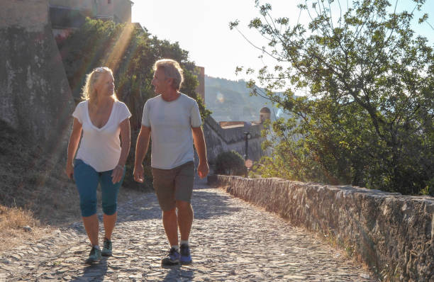 istock Couple walk along cobblestones by medieval castle 1152401059