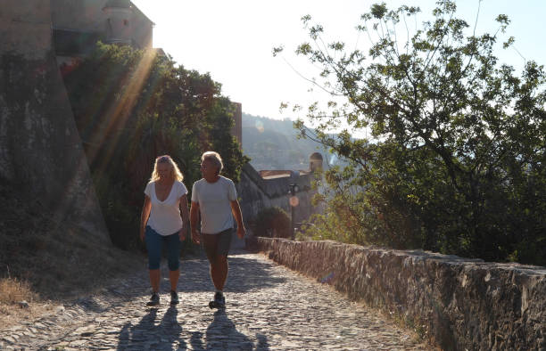 istock Couple walk along cobblestones by medieval castle 1152401067