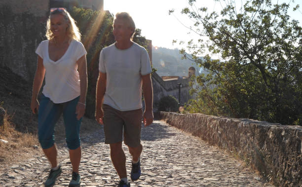 istock Couple walk along cobblestones by medieval castle 1152401078