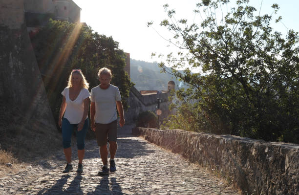 istock Couple walk along cobblestones by medieval castle 1152401115