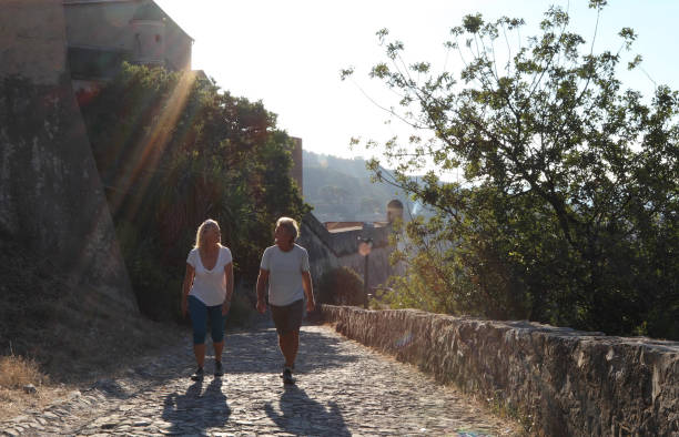 istock Couple walk along cobblestones by medieval castle 1152401140