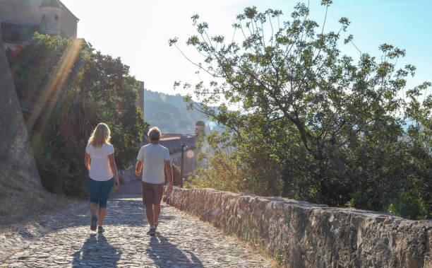 istock Couple walk along cobblestones by medieval castle 1152401145