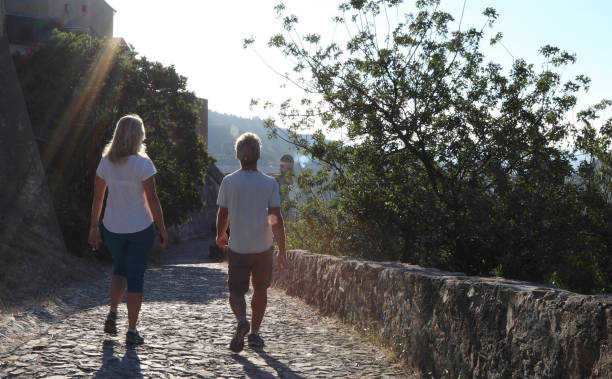 istock Couple walk along cobblestones by medieval castle 1152401165