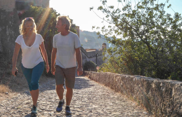 istock Couple walk along cobblestones by medieval castle 1152401166