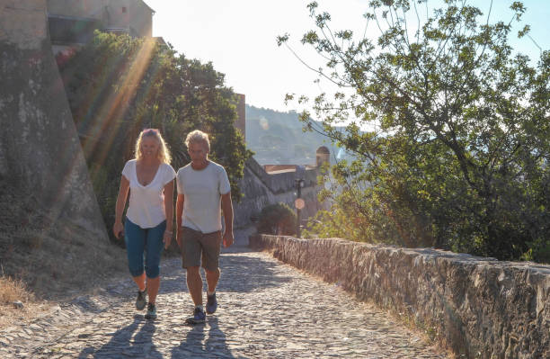 istock Couple walk along cobblestones by medieval castle 1152401174