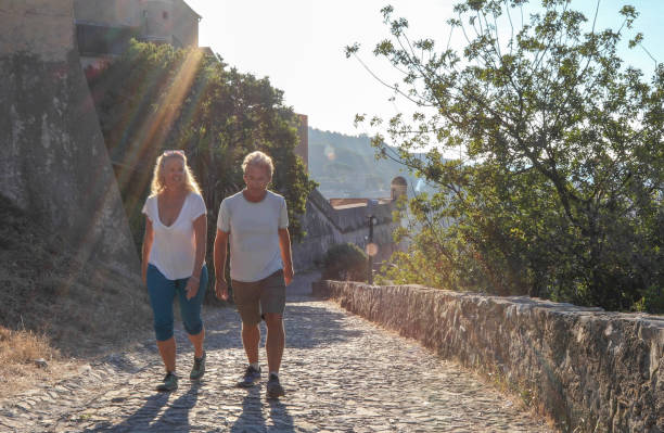 istock Couple walk along cobblestones by medieval castle 1152401191