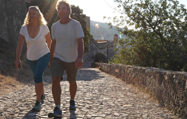 istock Couple walk along cobblestones by medieval castle 1152401213
