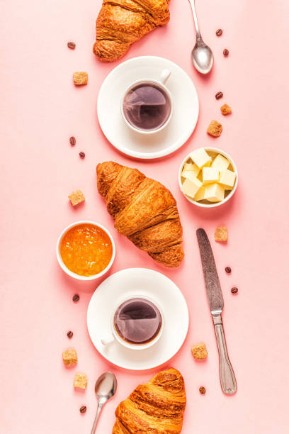 Coffee and croissants on pastel background