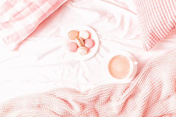 istock Bed with pink knitted plaid, coffee and macaroons 1152411142
