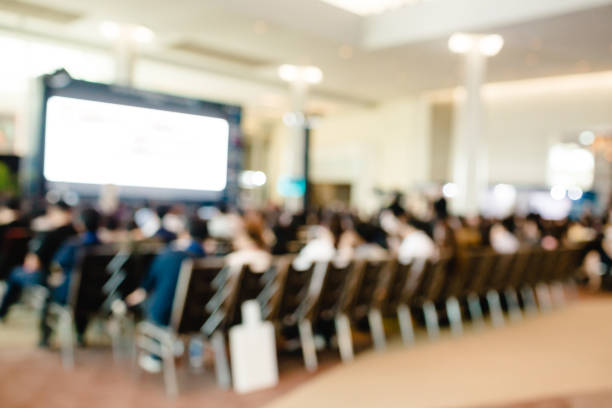 istock Blurry of auditorium for shareholders' meeting or seminar event with projector and white screen 1152411176