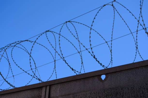 istock Barbed wire on fence with sky. 1152412710