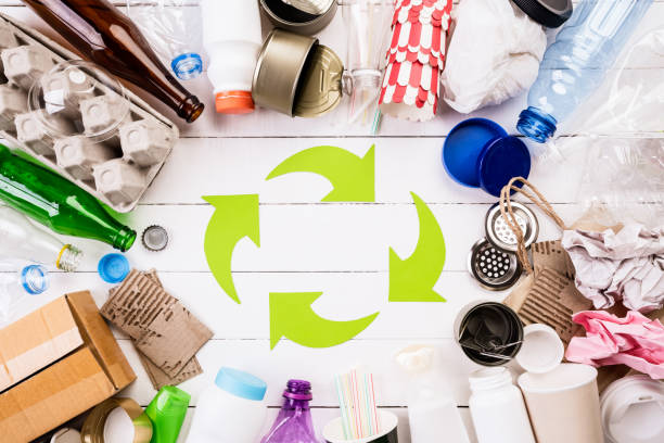 Top view of Different garbage materials with recycling symbol on white wooden table background. Recycle, World Environment Day and Eco concept