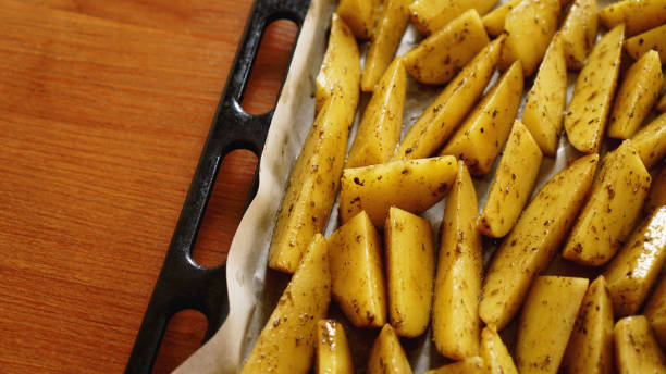 istock Sliced raw potatoes on a baking sheet with spices 1152414557