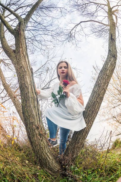 istock Woman with rose posing against lake water 1152415841