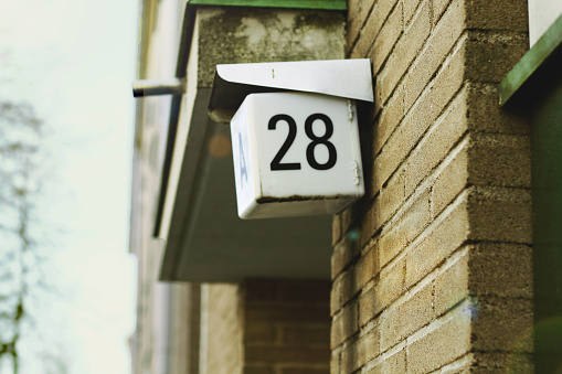 house number 28 at the corner of a beige brick European building
