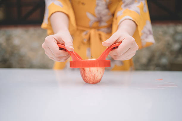 azjatycka chińska kobieta wycina jabłko poza kurort z jabłkiem corer - fruit salad fruit healthy eating making zdjęcia i obrazy z banku zdjęć