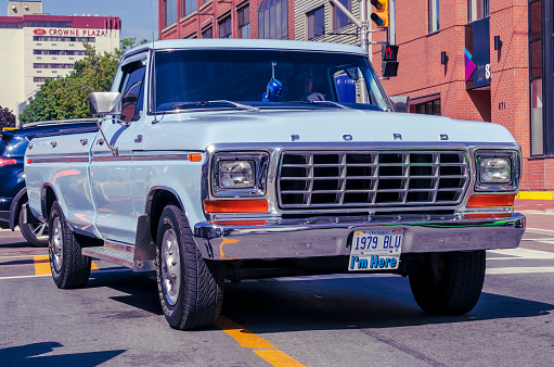 Moncton, New Brunswick, Canada - July 7, 2017 : Owner drives his 1979 Ford F150 pickup truck in the downtown area of Moncton, New Brunswick during 2017 Atlantic Nationals Automotive. Extravaganza.