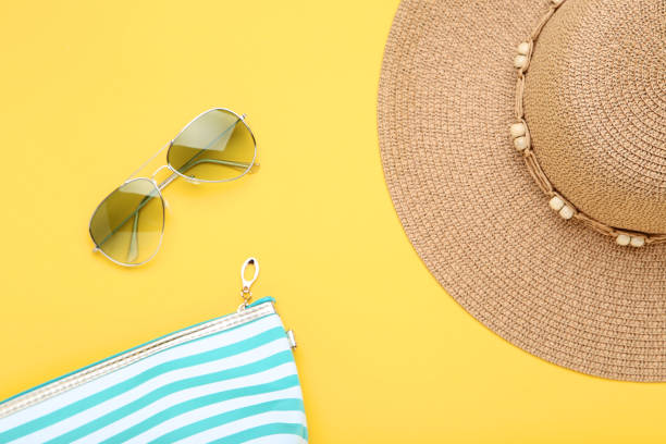 istock Beach hat with bag and sunglasses on yellow background 1152418331