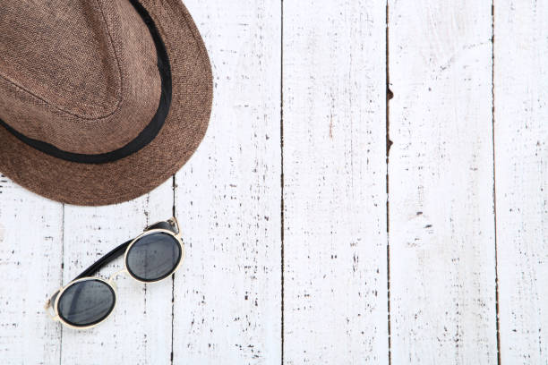 istock Brown hat with sunglasses on white wooden table 1152418735