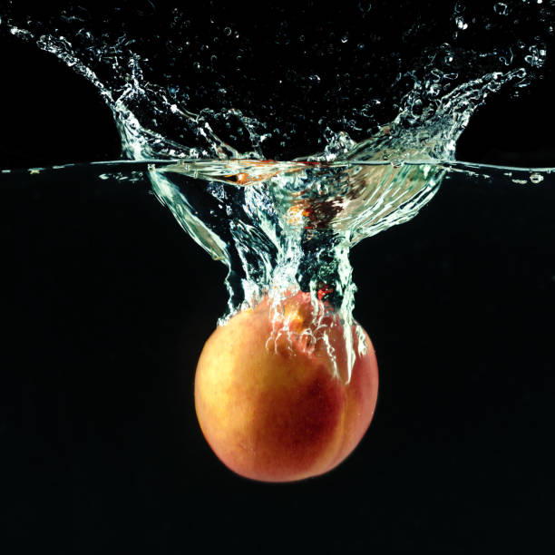 Peach dropped into water with bubbles
