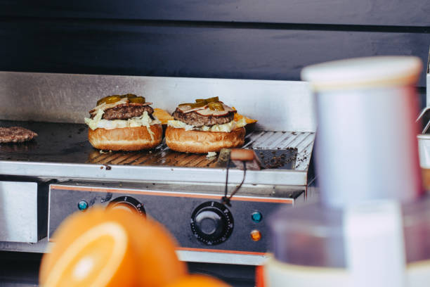 istock Cook preparing burger adding the sauce on the cream cheese. Three burgers. 1152420895