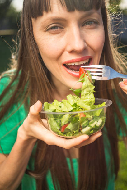 istock Beautiful woman eating salad 1152420942
