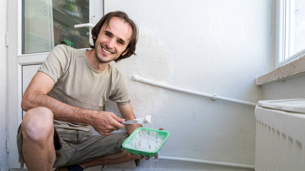istock Man applying plaster mix on the wall with spatula.  Easy home renovating concept. 1152422202