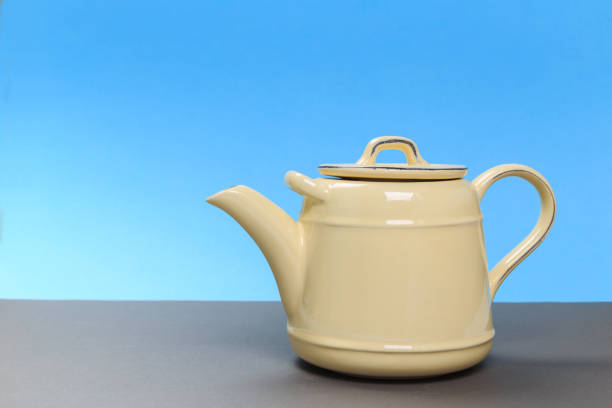 istock New rustic yellow porcelain teapot on a gray board and a blue background 1152422477