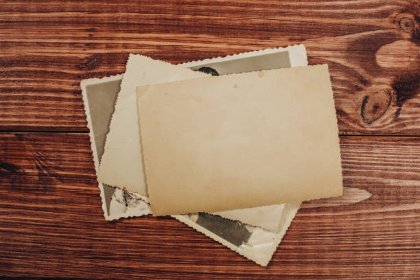 Stack old photos on table. Mock-up blank paper. Postcard rumpled and dirty vintage. Retro card