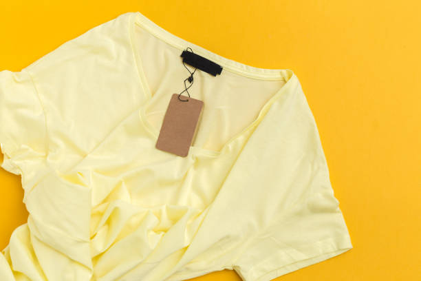 istock Yellow t-shirt with blank label tag top view 1152423835