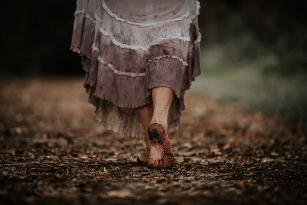 Power to walk away Woman wearing dirty white dress walking away barefoot on trail floor length stock pictures, royalty-free photos & images