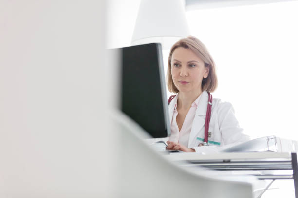 istock Confident woman using computer at desk in hospital 1152425213