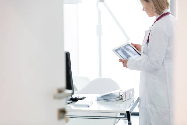 istock Doctor examining x-ray on digital tablet while standing at desk in hospital 1152426307
