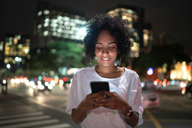 istock Woman using cellphone at night in the street 1152426953