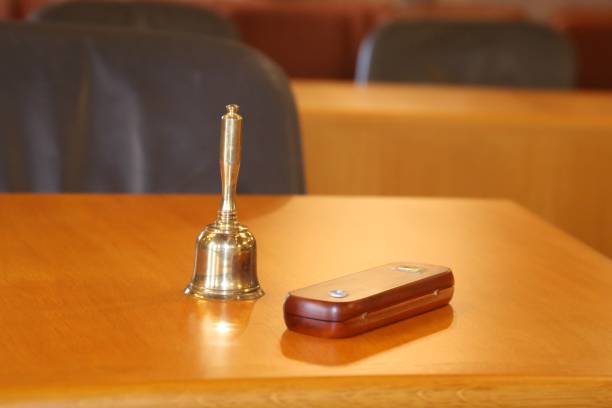 A hand holding a bell in a school