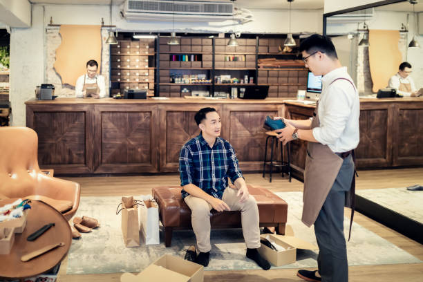 若い男が新しい靴を買う - shoe store sales clerk customer ストックフォトと画像