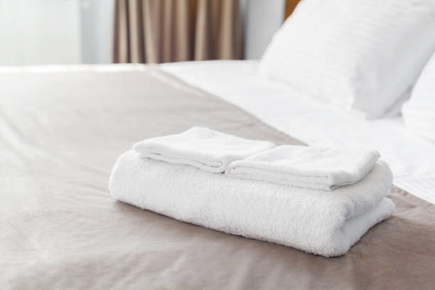istock White towel on bed in guest room for hotel customer 1152428552