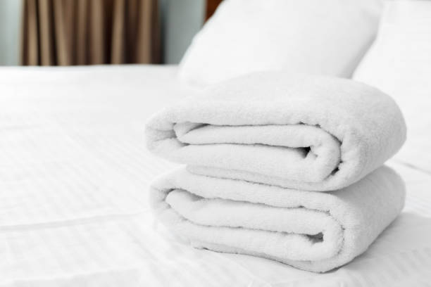 istock White towel on bed in guest room for hotel customer 1152429569