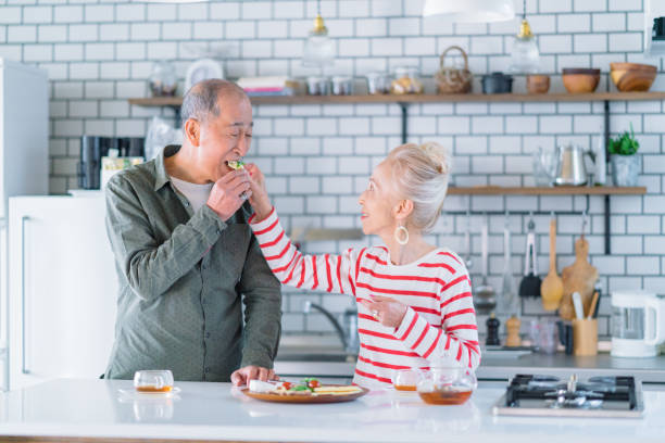 senior couple enjoying their time happily in kitchen - salad japanese culture japan asian culture imagens e fotografias de stock