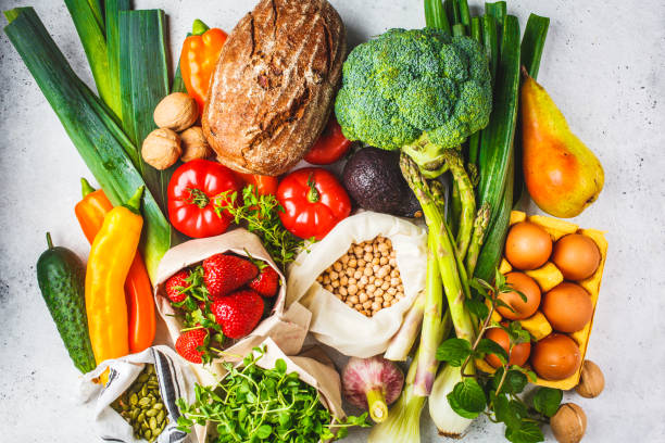 istock Balanced food background. Vegetables, fruits, nuts, sprouts, eggs, seeds, chickpeas on white background, top view. 1152434046
