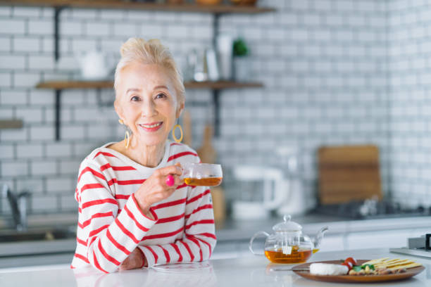 retrato da mulher sênior feliz na cozinha - salad japanese culture japan asian culture - fotografias e filmes do acervo