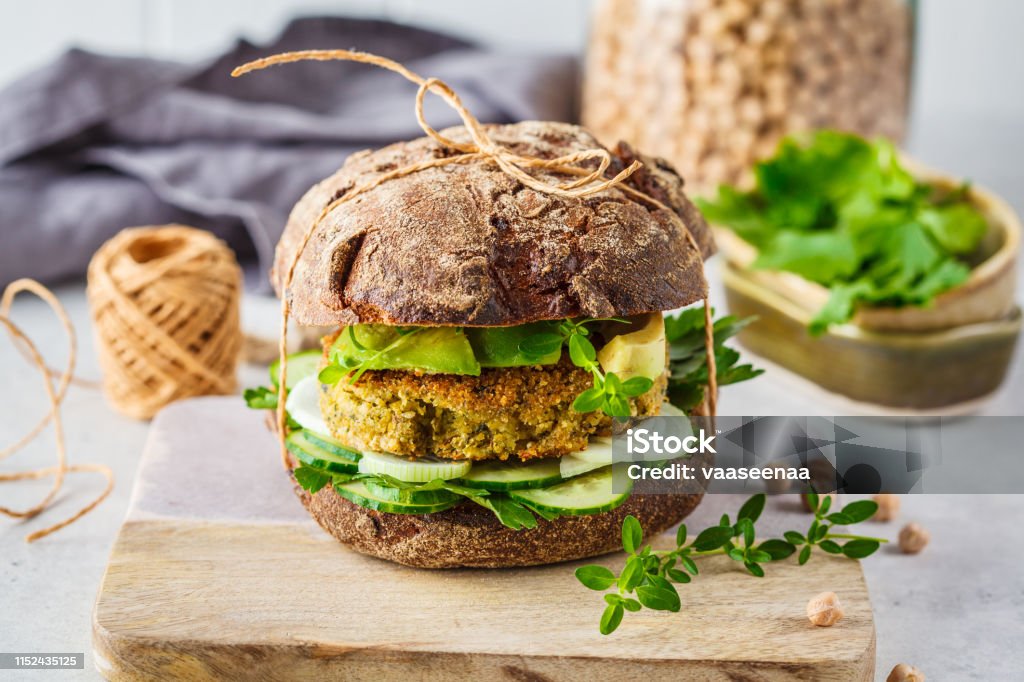 Vegan sandwich with chickpea patty, avocado, cucumber and greens in rye bread. Vegan sandwich with chickpea cutlet, avocado, cucumber and greens in rye bread. Veganism Stock Photo