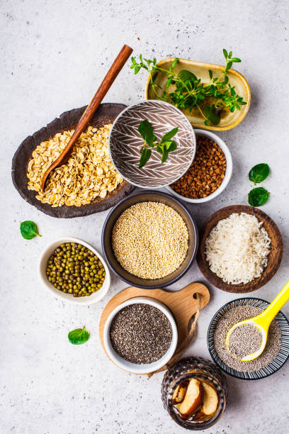 mat bakgrund-ris, chia frön, nötter, havregryn, bovete, quinoa, mungbönor och greener på en vit bakgrund. - supermat bildbanksfoton och bilder
